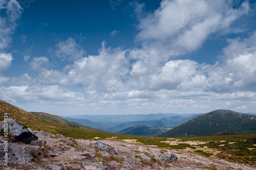 Beautiful scenery of spring mountains with green hills, slopes, blue sky with clouds. Carpathian mountains, Ukraine