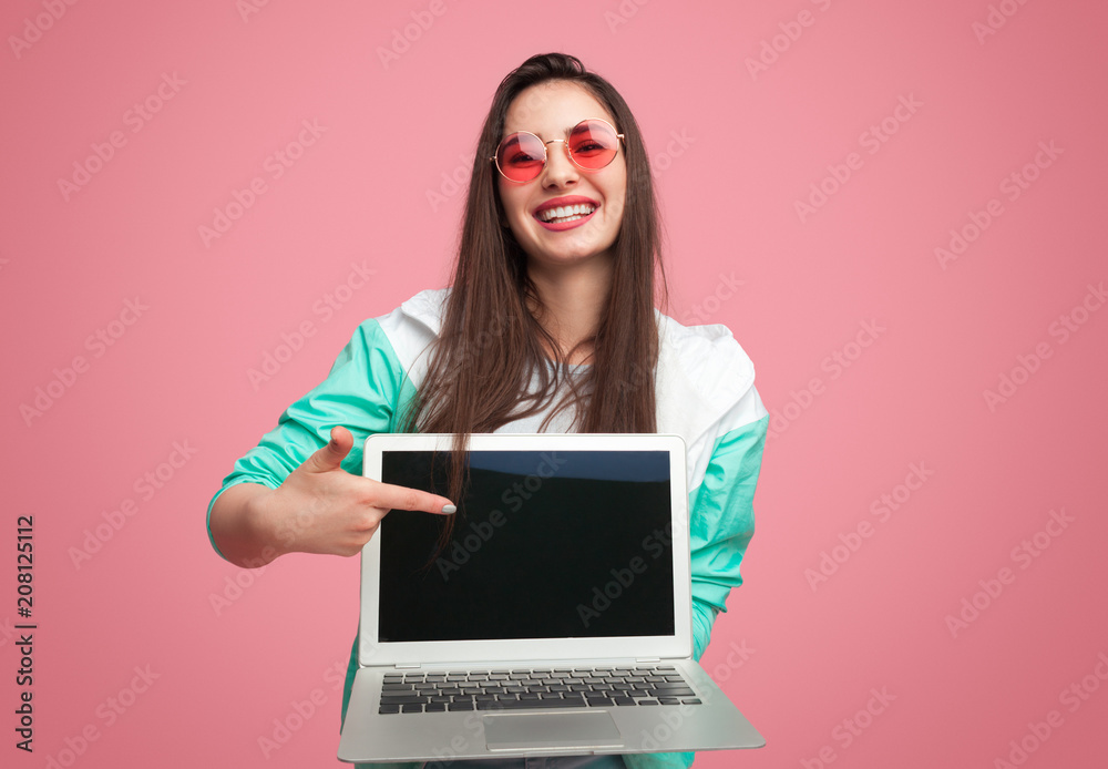 Laughing modern girl showing laptop Laughing modern girl showing laptop