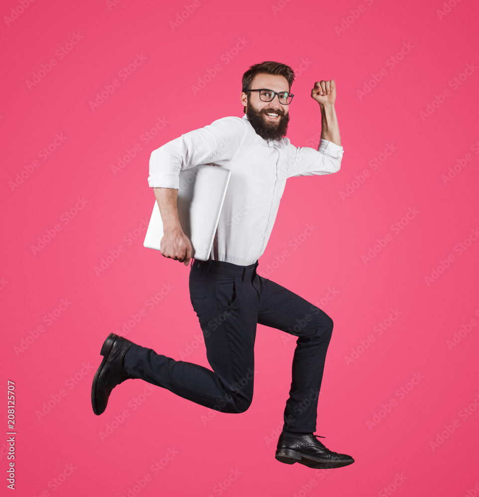 Formal man with laptop running on pink Formal man with laptop running on pink