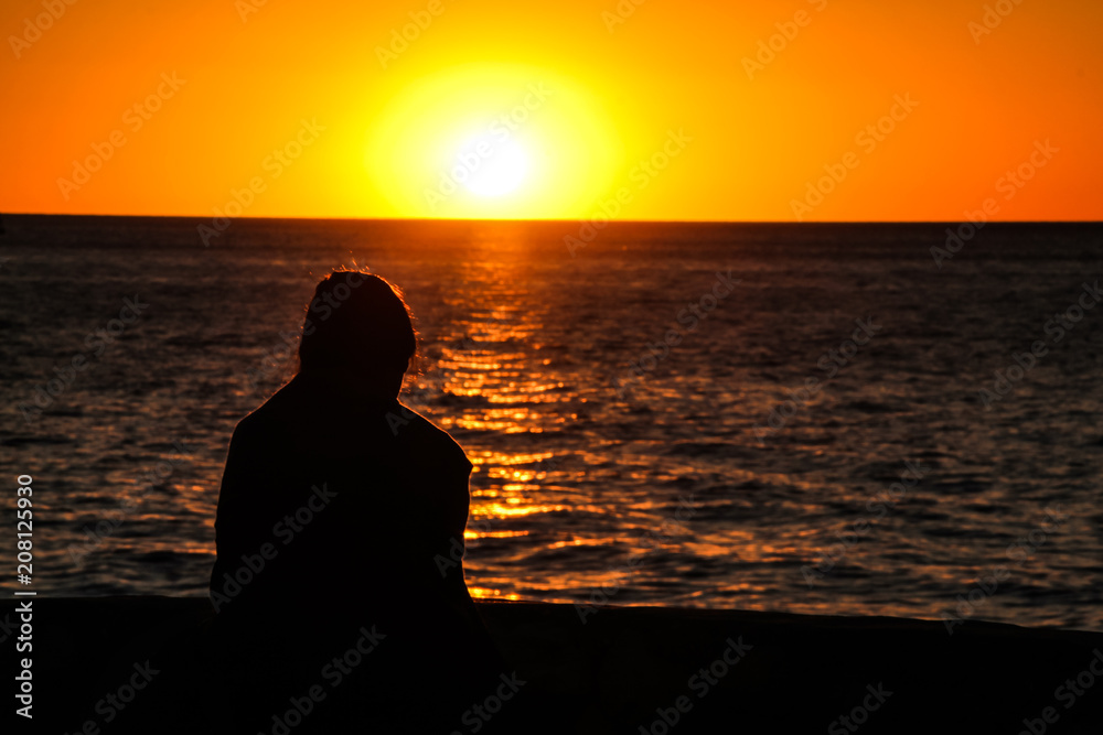 Beautiful woman's silhouette at sunset sea Beautiful woman's silhouette at sunset sea