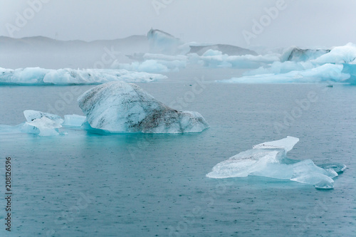 Drifting ice on a glacier lagoon in the rain  giving at bluish colour