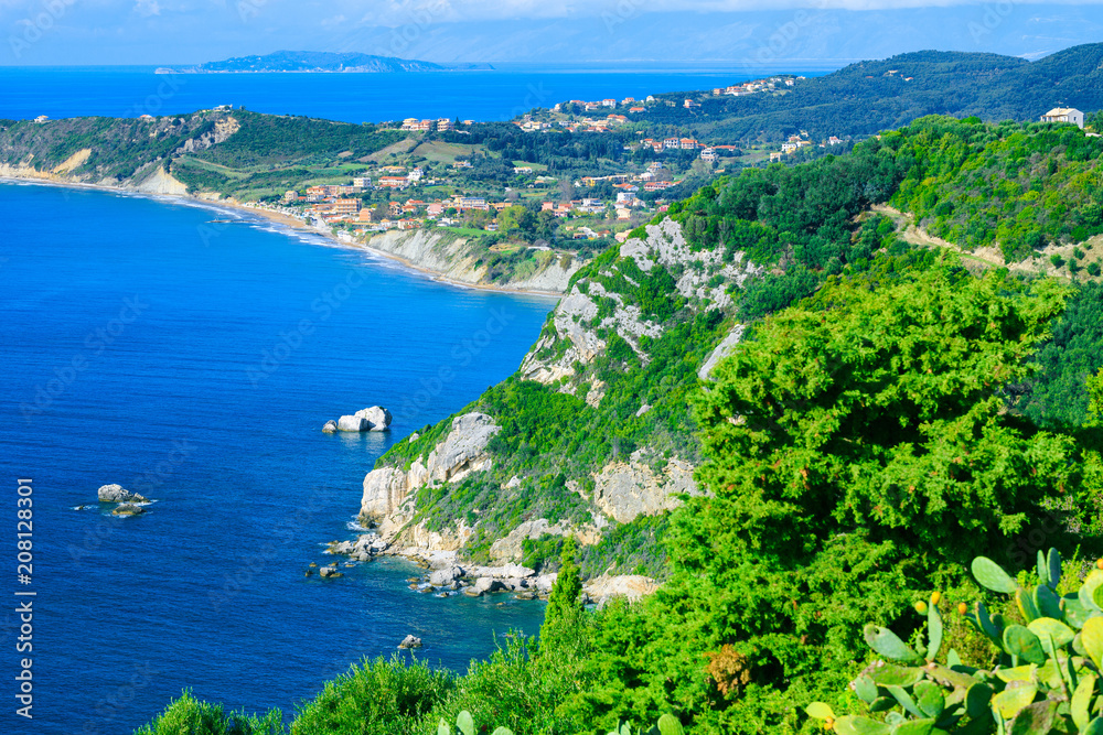 Beautiful summer seascape. Awesome view picturesque green hills coastline sea bay with crystal clear azure water, distant islands in the calm warm sea. Agios Stefanos cape. Afionas. Corfu. Greece.