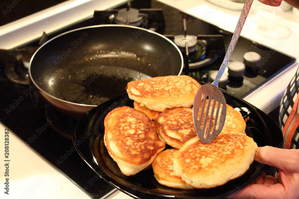 Preparation of pancakes in a frying pan on a gas stove. Fritters. Pancakes with milk. Close-up.