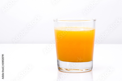 Fresh orange juice in the glass on an light background, horiizontal with place for a text.