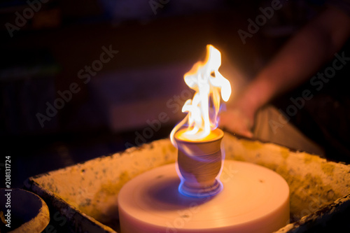 Burning ceramic mug on pottery wheel in workshop, studio. Handmade, art and handicraft concept