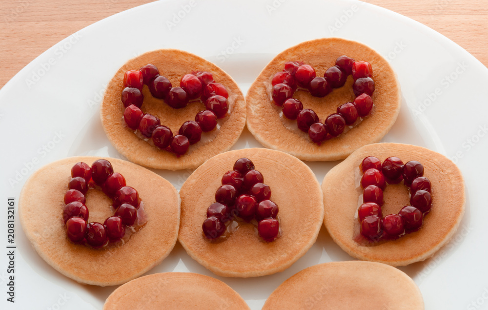 Pancakes with maple syrup and cranberries on a white plate. Concept Father’s day. Greeting Card, Gift, Surprise. Two Hearts and text Dad. Idea Family Brunch, Breakfast. Snacks. Sweets. Food.