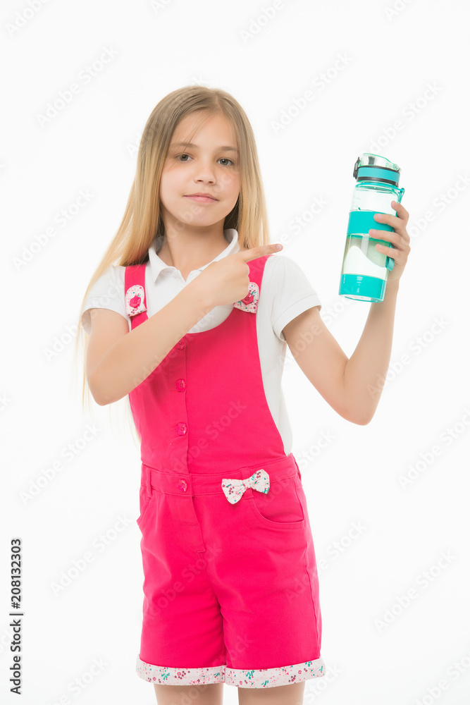 Girl on smiling face posing with bottle of water, isolated on white background. Kid girl with long hair pointing at bottle with water. Water balance concept. Girl cares about health and water balance Girl on smiling face posing with bottle of water, isolated on white background. Kid girl with long hair pointing at bottle with water. Water balance concept. Girl cares about health and water balance