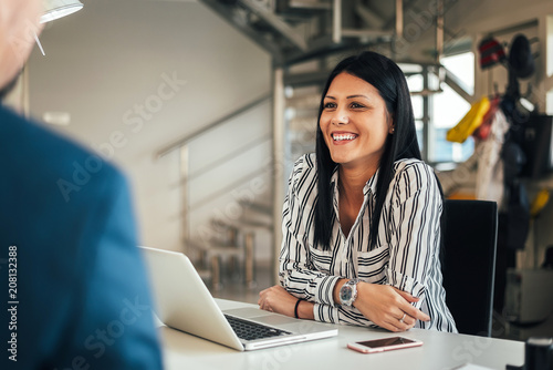 Young smiling saleswoman talking with a client. photo