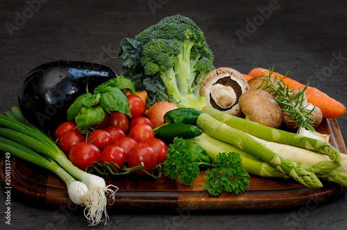  Wooden plate with fresh  colorful  various vegetables on a dark background