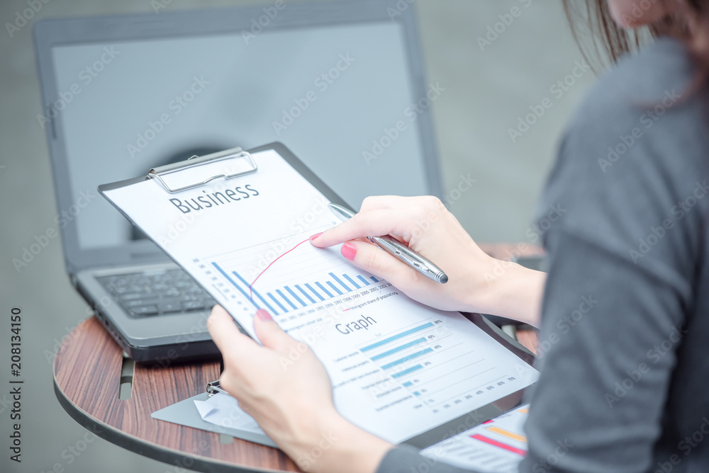 Fototapeta premium Young attractive Asian business woman sitting on workplace, woman using laptop while sitting at her desk