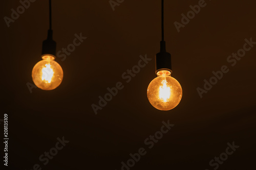 Lamp bulb with light on the ceiling and a selection with black background