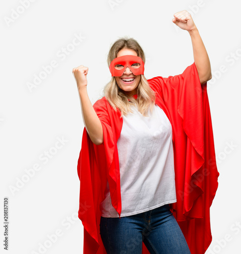Young super hero woman wearing cape happy and excited celebrating victory expressing big success, power, energy and positive emotions. Celebrates new job joyful