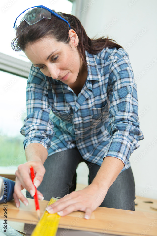 woman measuring a board for cutting woman measuring a board for cutting