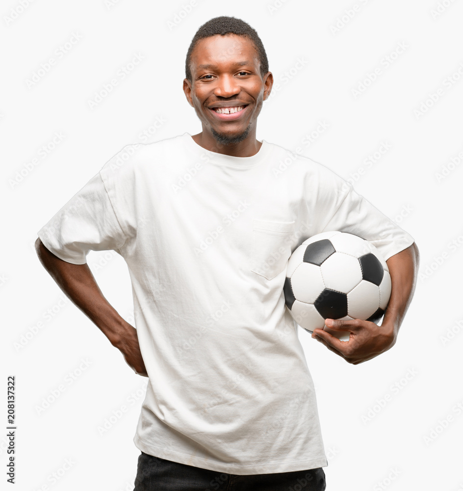 African black man holding soccer ball with crossed arms confident and happy with a big natural smile laughing African black man holding soccer ball with crossed arms confident and happy with a big natural smile laughing