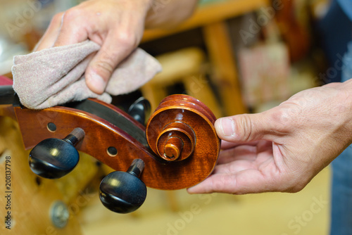 Hands polishing end of musical instrument