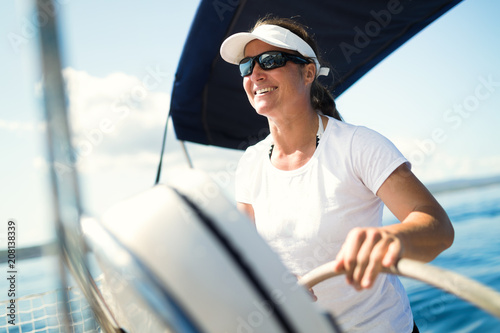 Attractive strong woman sailing with her boat