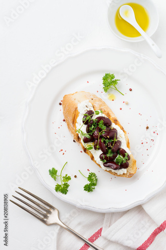 Sandwich with red beans, garlic, olive oil and curd cheese on white background. Mexican Cuisine. Top view.