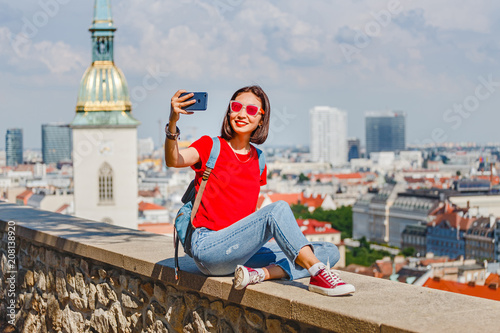 Young beautiful asian woman taking selfie at the background of the city - traveler and social network concept photo