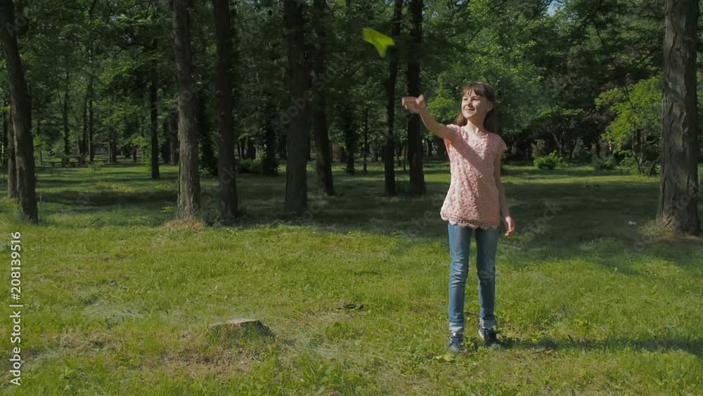 A child with a paper plane dreams. Little girl is playing with paper airplane in nature. A child with a paper plane dreams. Little girl is playing with paper airplane in nature.