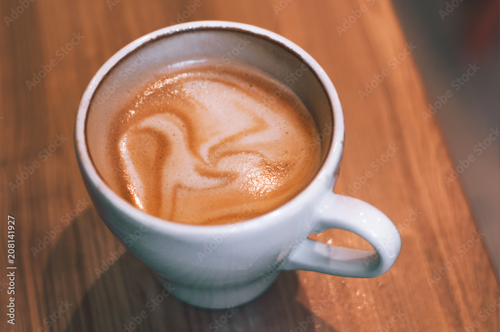 Top view of hot coffee cappuccino latte in white ceramic cup on marble table. Coffee cup top view on old wooden. Coffee cup in coffee shop Top view of hot coffee cappuccino latte in white ceramic cup on marble table. Coffee cup top view on old wooden. Coffee cup in coffee shop