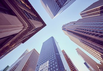 Looking up at New York skyscrapers at sunset, color toned picture, USA.
