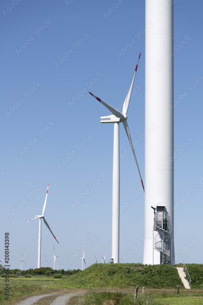 Aufgang und Basis eines Windrads mit Windrädern im Hintergrund Aufgang und Basis eines Windrads mit Windrädern im Hintergrund