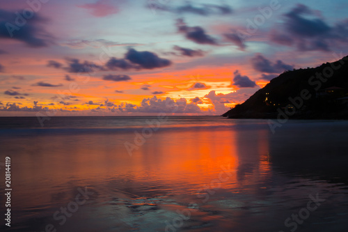 Sunset with the beautiful purple sky and orange clouds over the view of andaman sea at naiharn beach phuket.