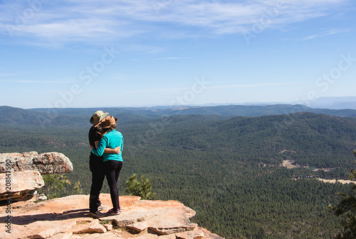 traveler young couple hugging and wahtcing the forest scenery