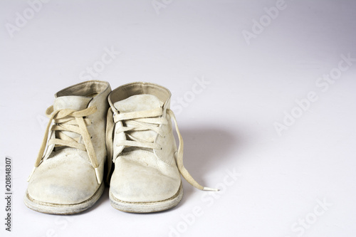 1955 era used white baby shoes isolated on white background