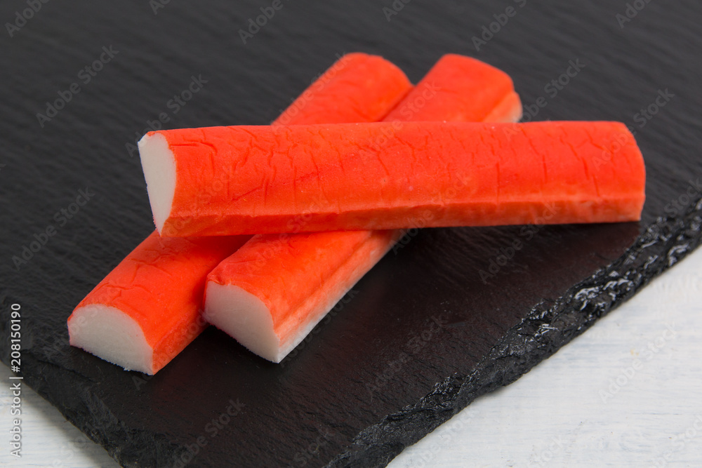crab sticks on black stone background crab sticks on black stone background