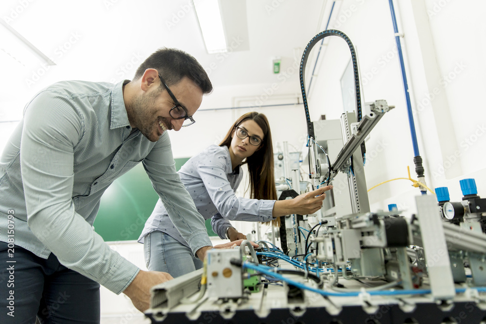 Fototapeta premium Young couple of students working at robotics lab