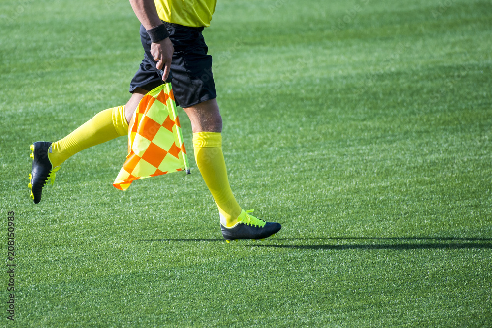 Fototapeta premium Assistant referee moving along the sideline during a soccer match