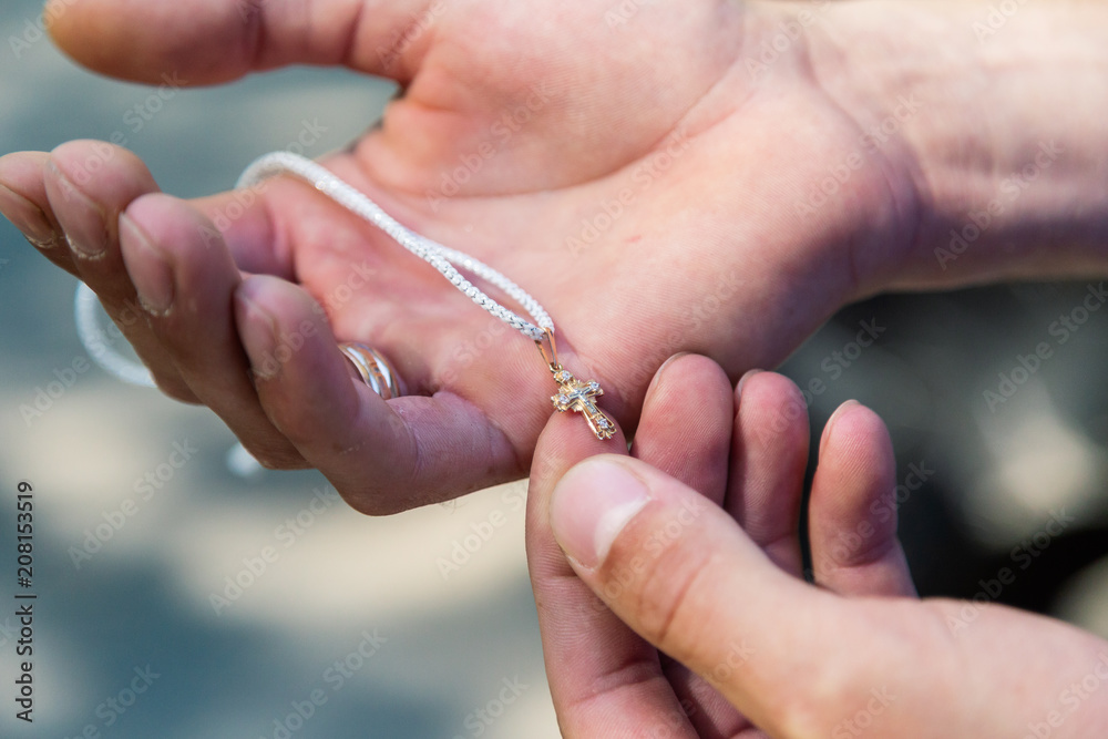 Cross for the rite of baptism in the palm of a man. Cross for the rite of baptism in the palm of a man.