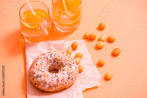 Sprinkled Pink Donut. Frosted sprinkled donut on pink background. photo