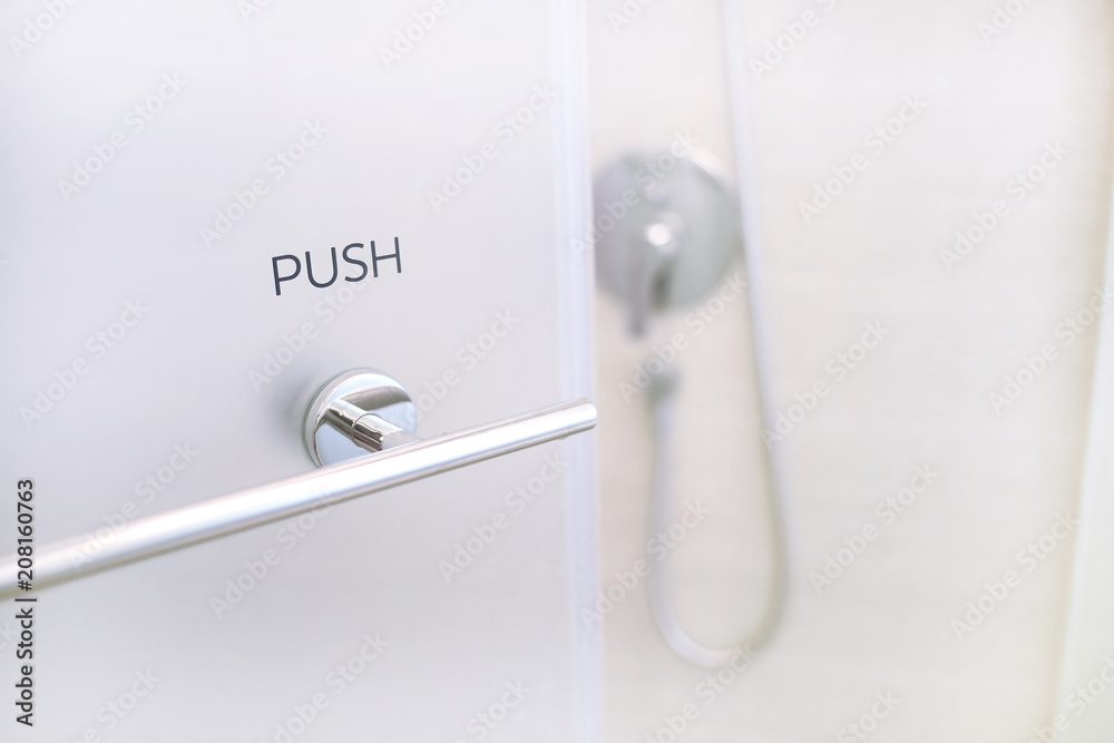 Detail of a modern glass shower cabin. Open shower door Detail of a modern glass shower cabin. Open shower door