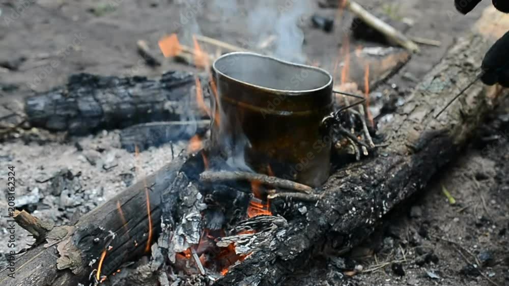 Cooking food on the campfire in the summer forest. Slow motion footage with man hands Cooking food on the campfire in the summer forest. Slow motion footage with man hands