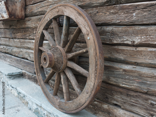 Antique wooden wheel of carriage isolated on an old wall