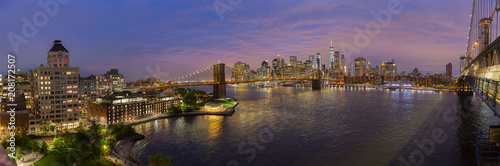 Brooklyn, Brooklyn park, Brooklyn Bridge, Janes Carousel and Lower Manhattan skyline at night seen from Manhattan bridge, New York city, USA. Wide angle panoramic image.