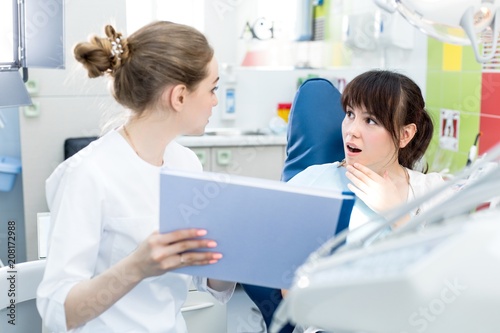Woman dentist shows the patient the bad results of the examination in the dental clinic