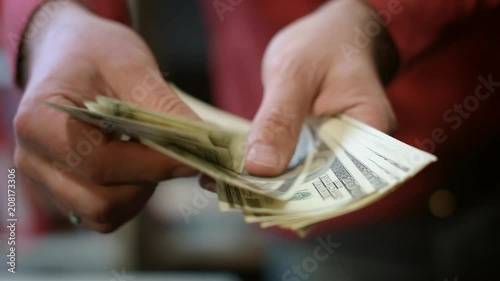Businessman calculate money income. Close up of busness man hands counting money cash. Male hands count dollar bills. Finance business success concept. Currency exchange service photo