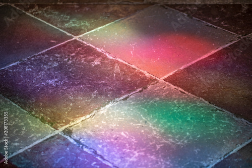 Vivid colorful stained-glass window light patches on the stone flooring in the cathedral in Gniezno, Poland. photo