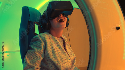 Excited young woman enjoying virtual reality attraction