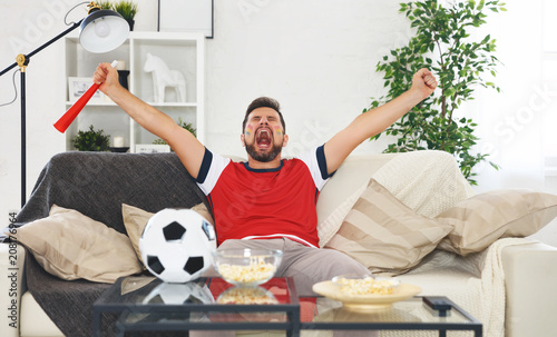 male soccer  fan watching a football match at home © JenkoAtaman