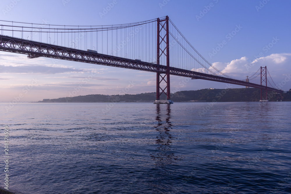 Huge suspension bridge over the river. View of the river, the clear sky and the bridge. Huge suspension bridge over the river. View of the river, the clear sky and the bridge.