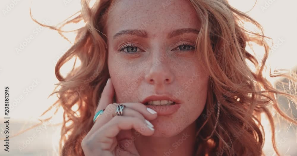 Close-up of young redhead bohemian woman with freckles in summer