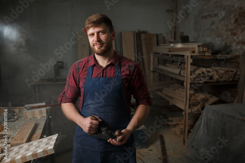 Portrait Male Master carpenter apron in his workshop. Small business © horimono