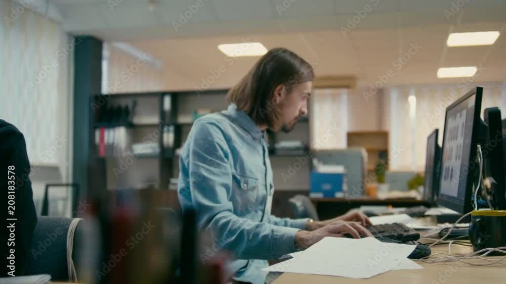 Young Lady and Man are Working in the Office with Computers Discussing Design Project Together Young Lady and Man are Working in the Office with Computers Discussing Design Project Together