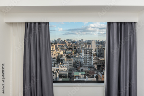 Beautiful view from the bedroom with window curtains and cityscape  blue sky  modern home decor.