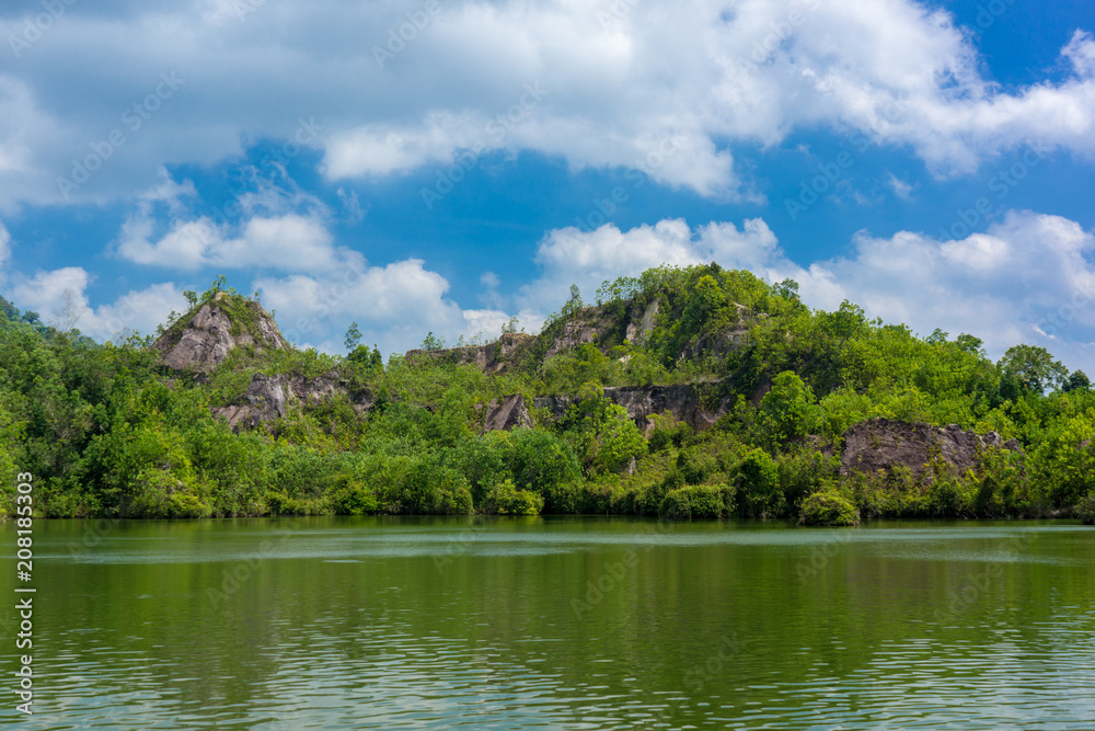rocky mountain with natural lake against clouds and blue sky, Thailand