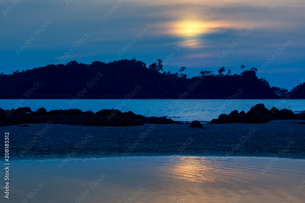beautiful and heavenly sunset at the mountains and sea landscape with reflection on water surface, Southern of Thailand